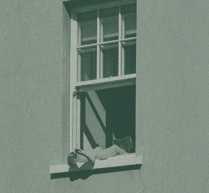 A person leaning out of an open window of a building, resting their arms on the windowsill in a quiet, contemplative moment