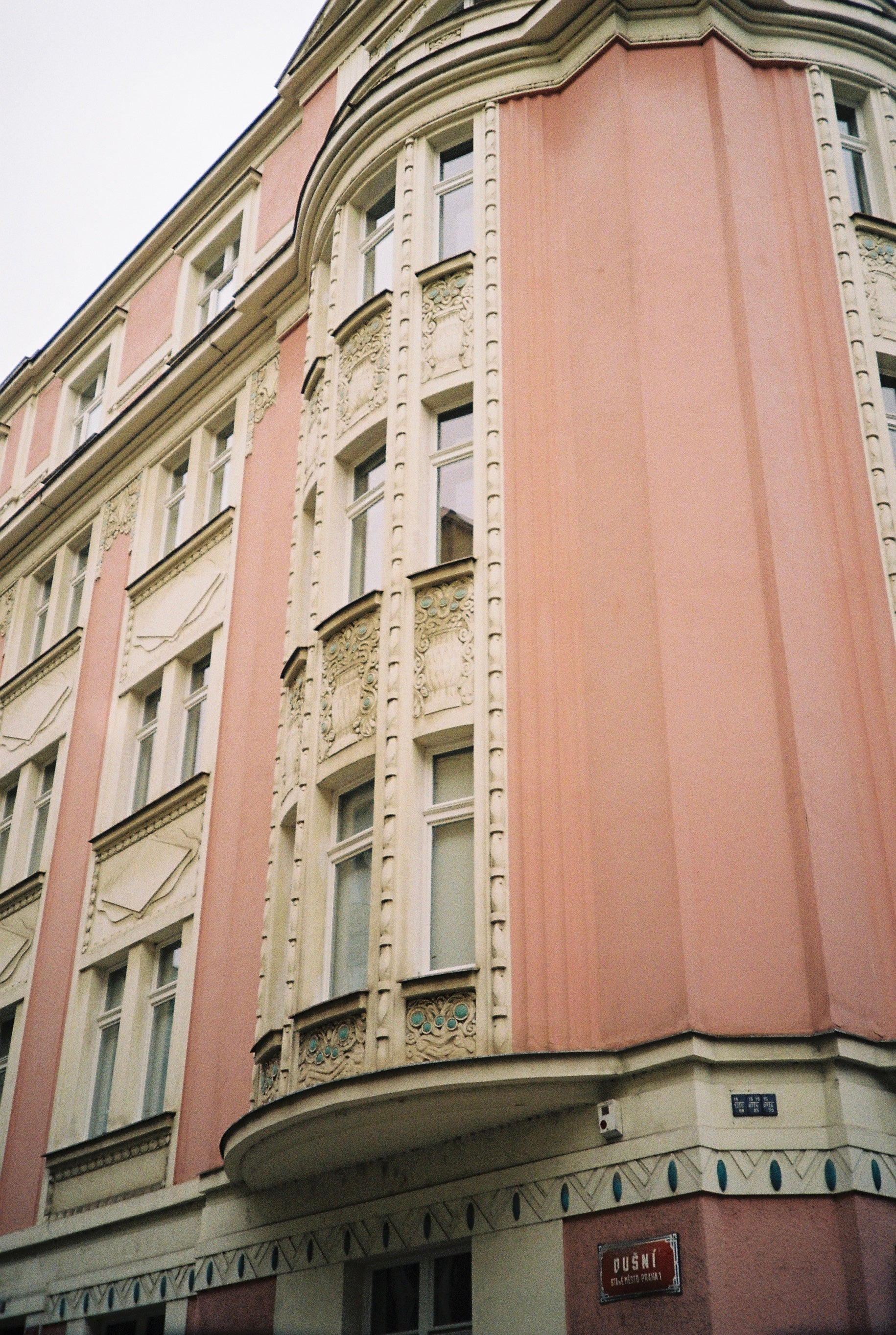 Classic building facade in pink and cream tones with ornate details.