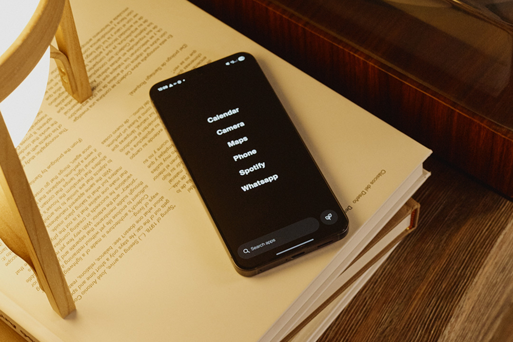 Smartphone on an open book with a wooden lamp in the background