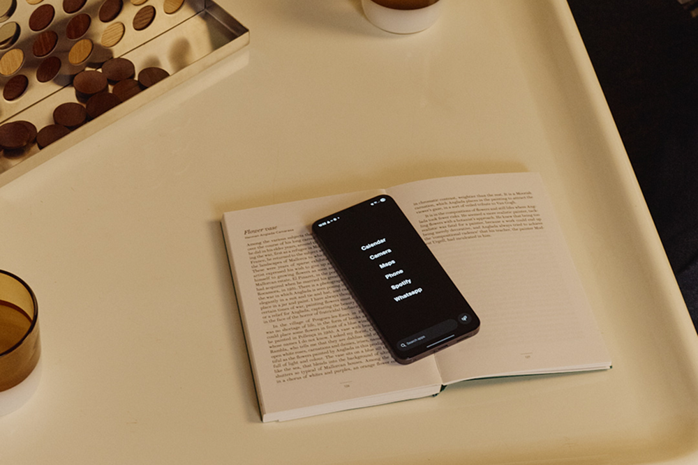 Phone on an open book with a cup and board game in the background
