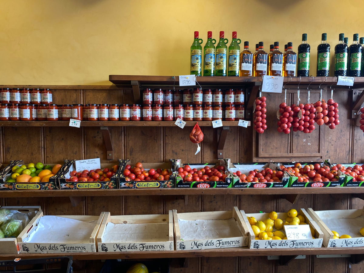 Market shelves with tomatoes, olive oil and preserves